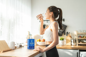 Woman drinking water Sunfiber on counter